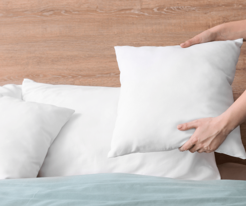 Image of pillows being placed on bed